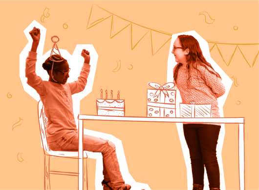 Twee meiden op een kinderfeestje. Één meisje zit met haar handen in de lucht juichend achter een taart. Een ander meisje kijkt lachend toe bij een stapel cadeau’s